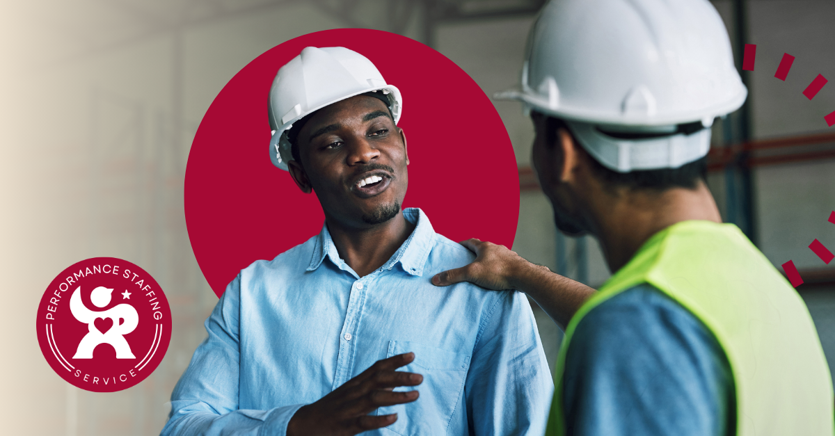 A man talking to another man in a hard hat.