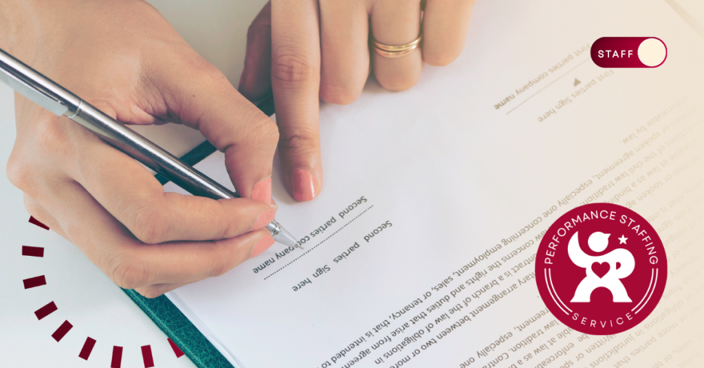 A person writing on a paper with a pen.